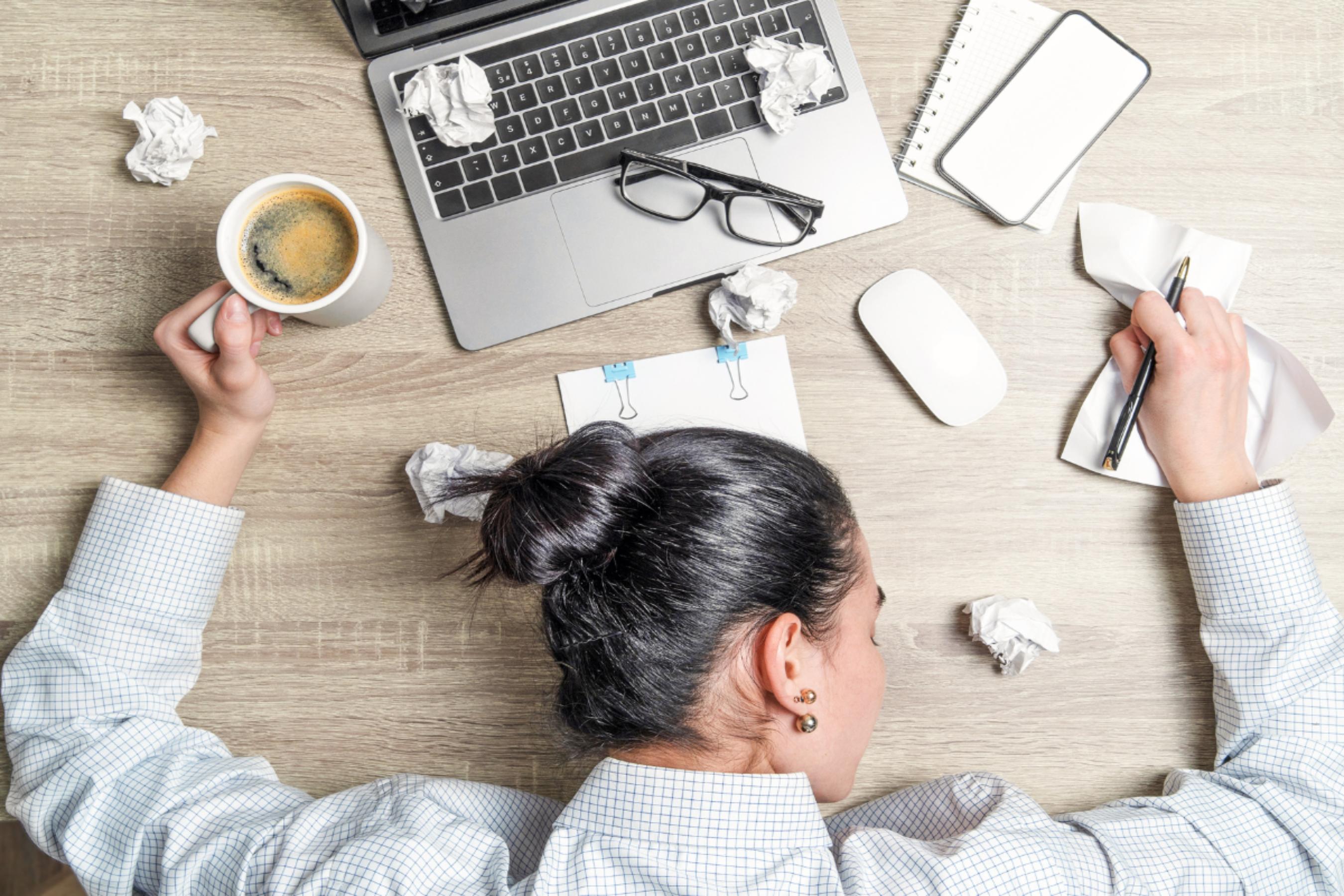 A desk with an open laptop and to-do list, representing end-of-year pressure in business