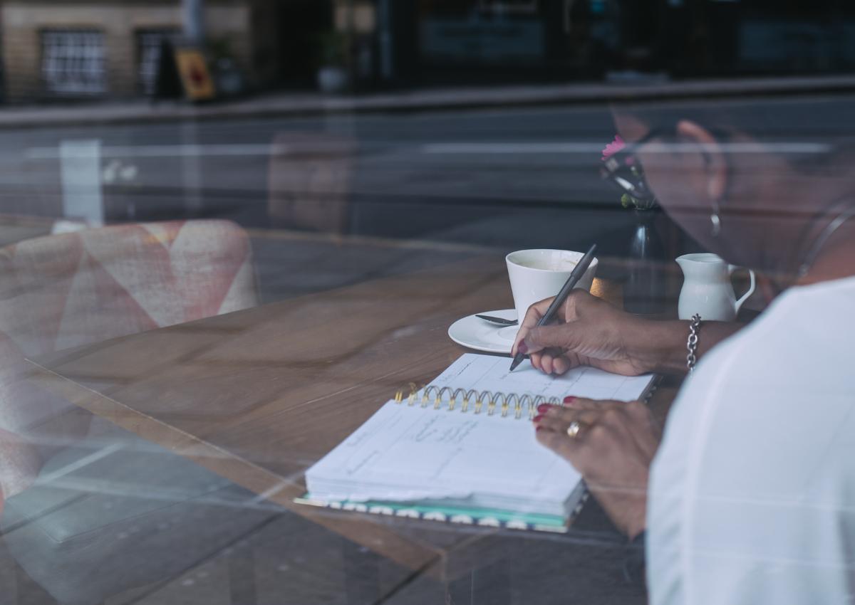 A calming desk scene with a notebook and tea, representing supportive 1:1 business coaching for career change.