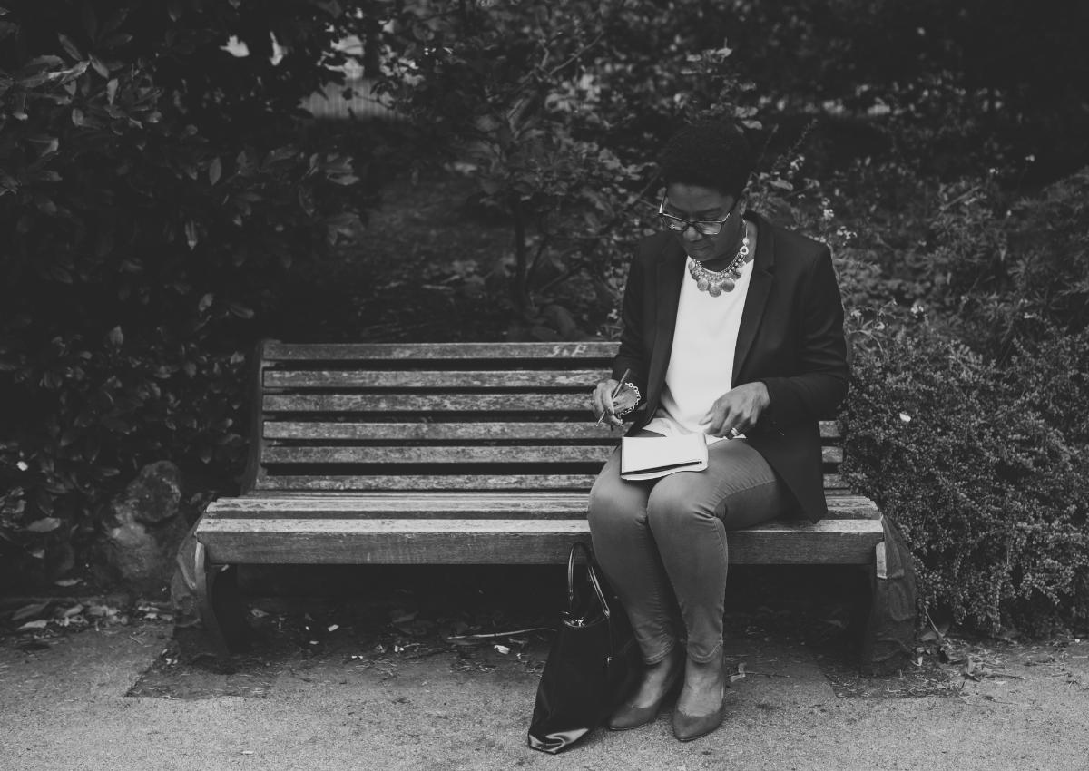 A person sitting alone in a peaceful outdoor setting, reflecting before making a major career decision.