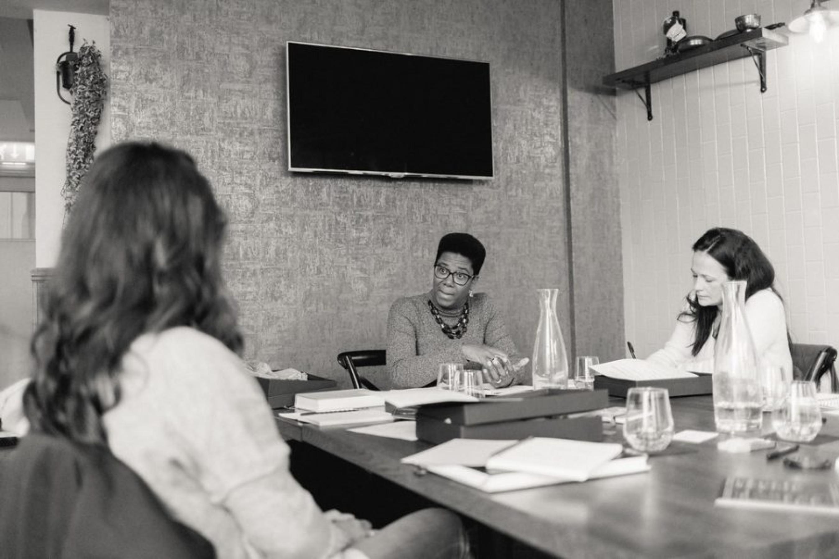 Small group of professionals collaborating around a table during a mastermind coaching session