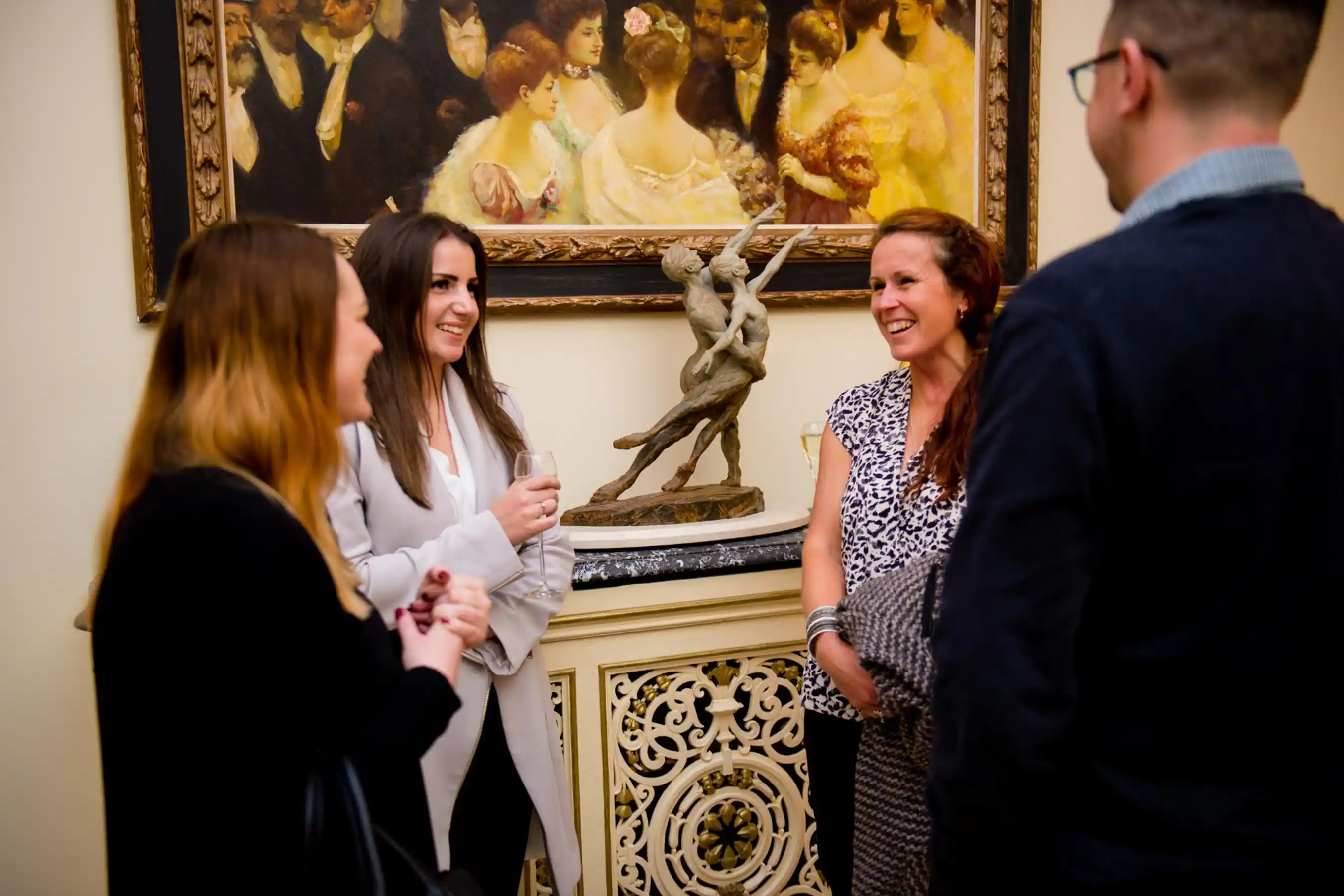 People having a conversation at an in-person networking event.