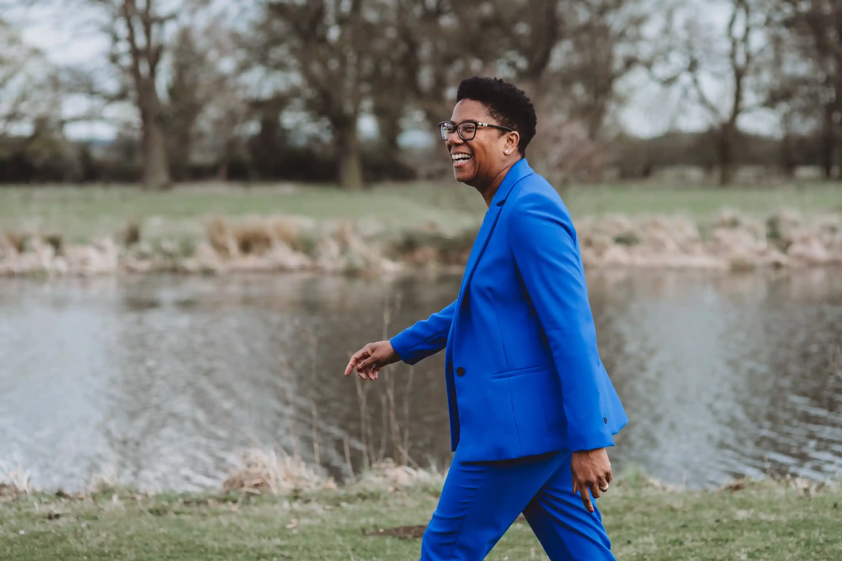 Business coach Val Mattinson walking along a river in a relaxed setting, looking happy and relaxed